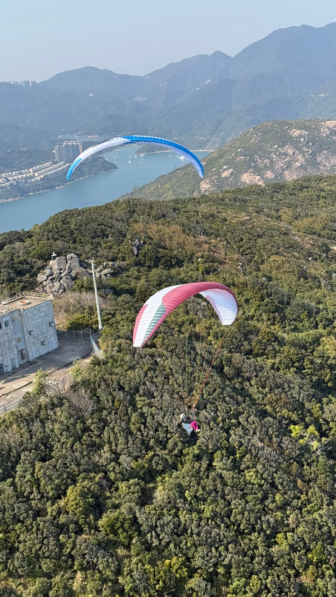 Tandem passenger smiling in flight near coastline